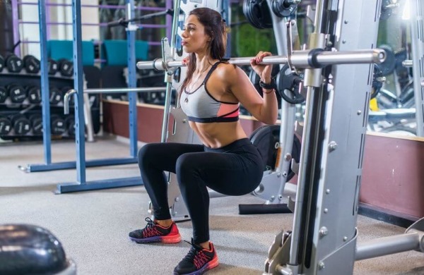 Smith squat cho con gái. Kỹ thuật thực hiện các động tác tập mông, đầu gối, co một chân, cơ tứ đầu đùi, tư thế thẳng lưng rộng hẹp.