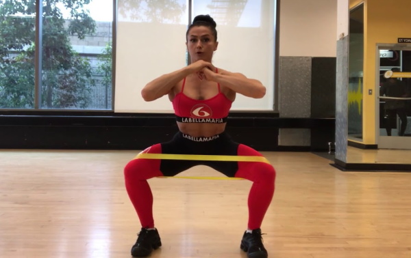 Squats dengan elastik pada kaki untuk punggung. Kesan otot mana yang berfungsi