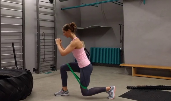 Squats dengan elastik pada kaki untuk punggung. Kesan otot mana yang berfungsi